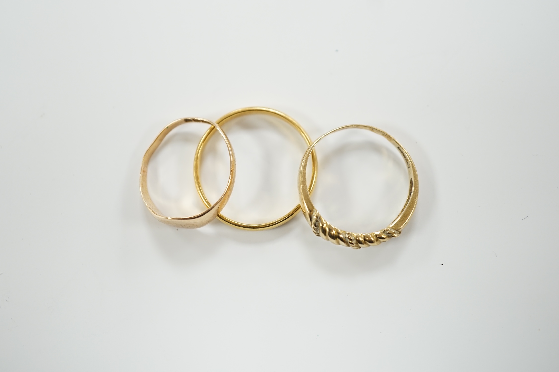 A 22ct gold wedding band, 3.4 grams, a 9ct gold signet ring, 16 grams and a yellow metal ring.